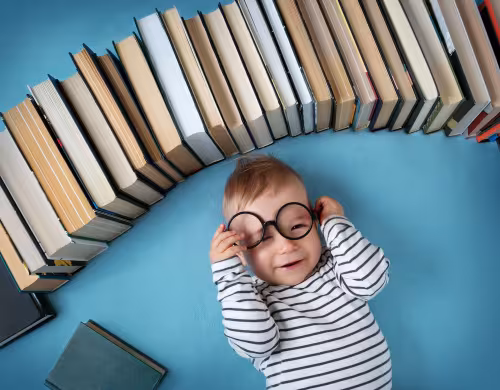 Bébé souriant entouré de livres